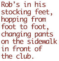 Rob's in his stocking feet, hopping from foot to foot, changing pants on the sidewalk in front of the club.